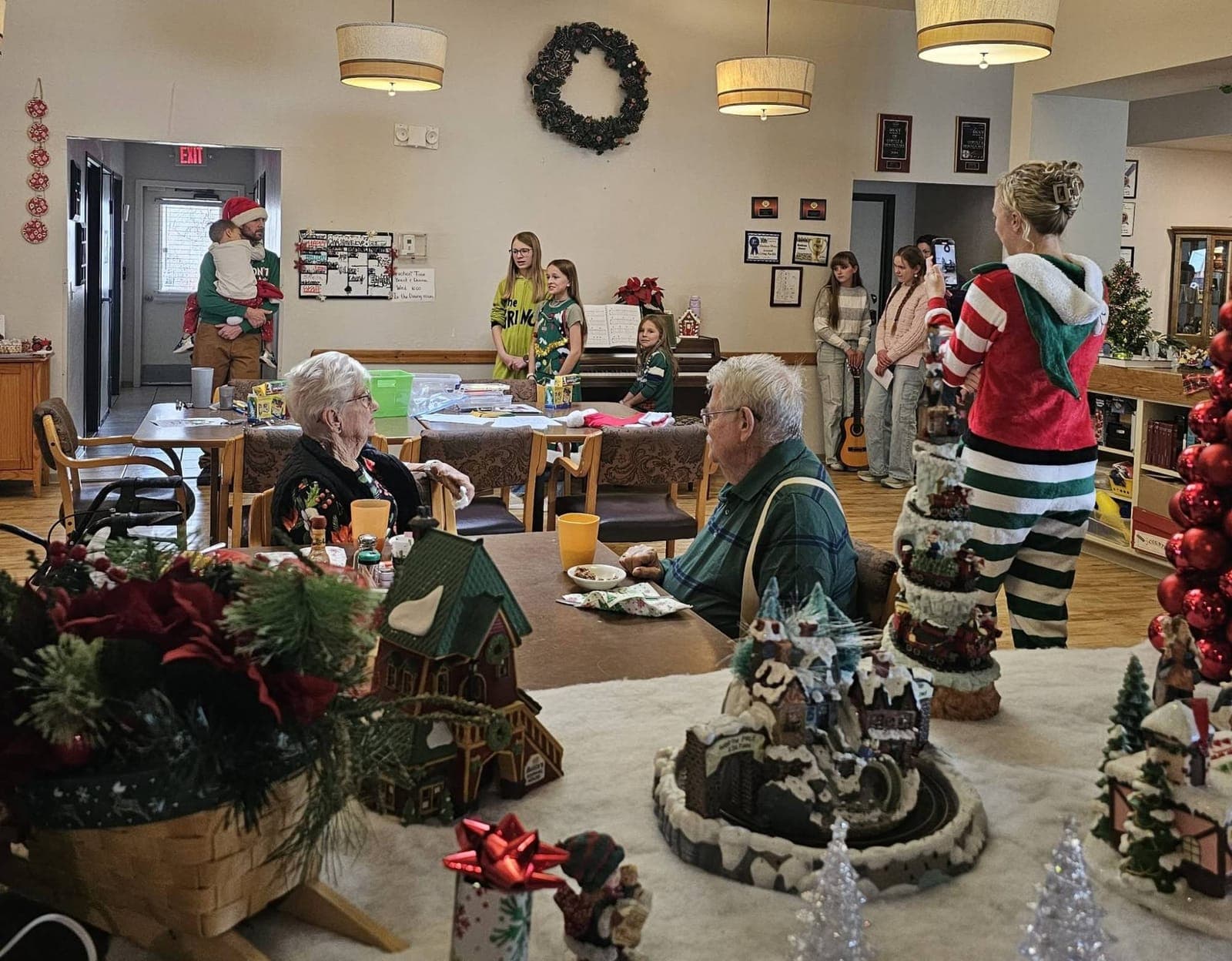 Children in holiday outfits sing a Christmas concert for residents in the decorated dining room at Madison House, Cortez, CO