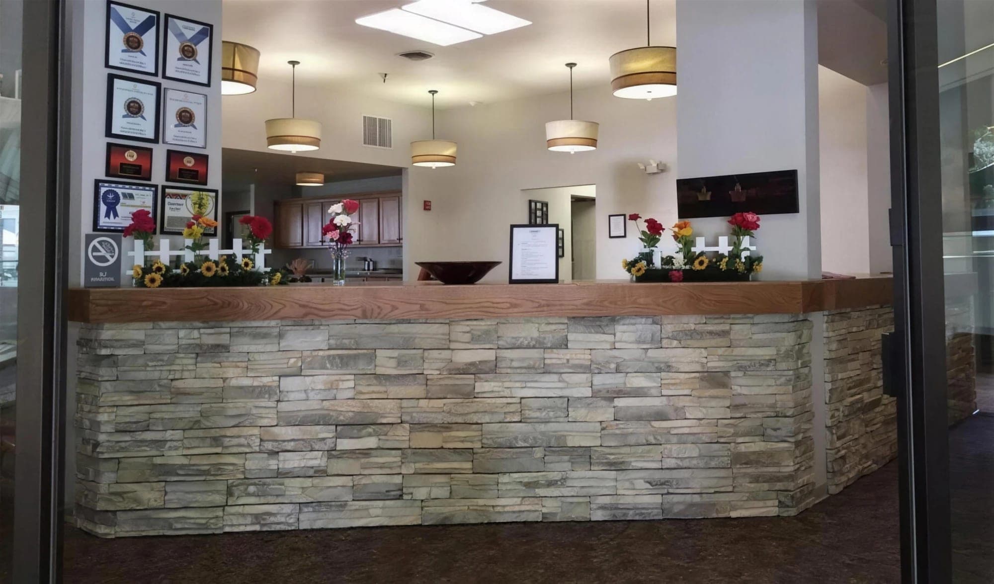 The stone-and-wood front reception desk in the lobby at Madison House in Cortez, Colorado
